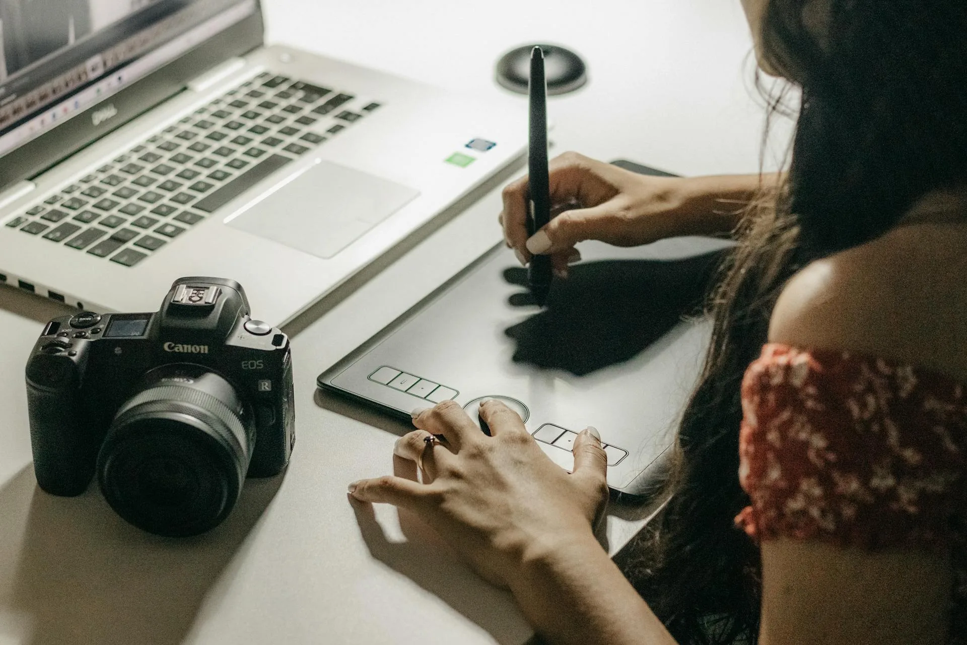 Graphic designer working on brand artwork using a tablet and laptop