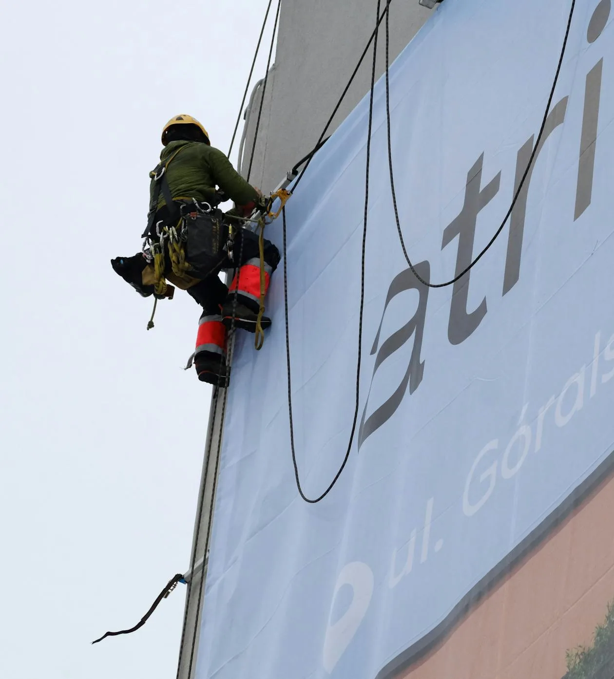 Sign installer fitting a fascia sign to a shop front