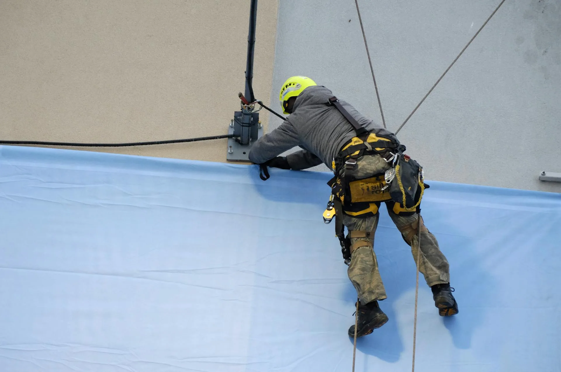 Technician installing a large sign or banner on a building facade