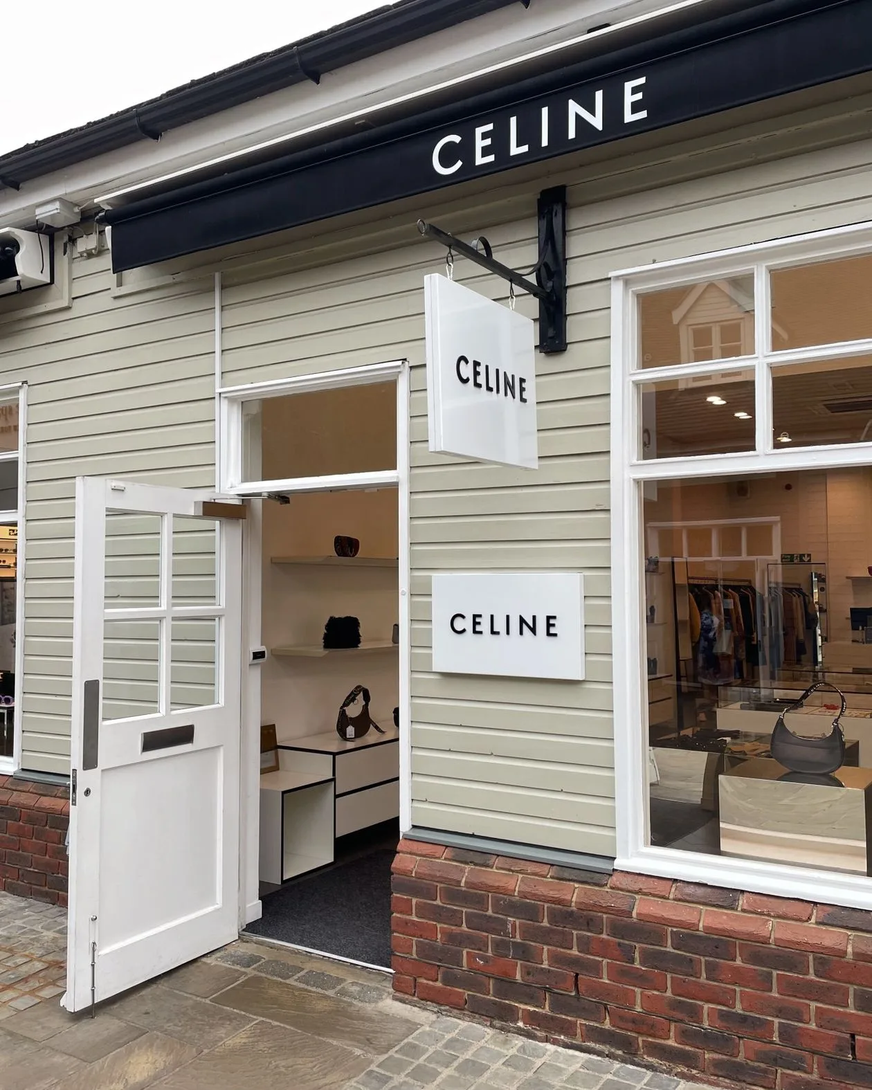 Chic boutique shopfront in England with fascia sign above entrance and window display