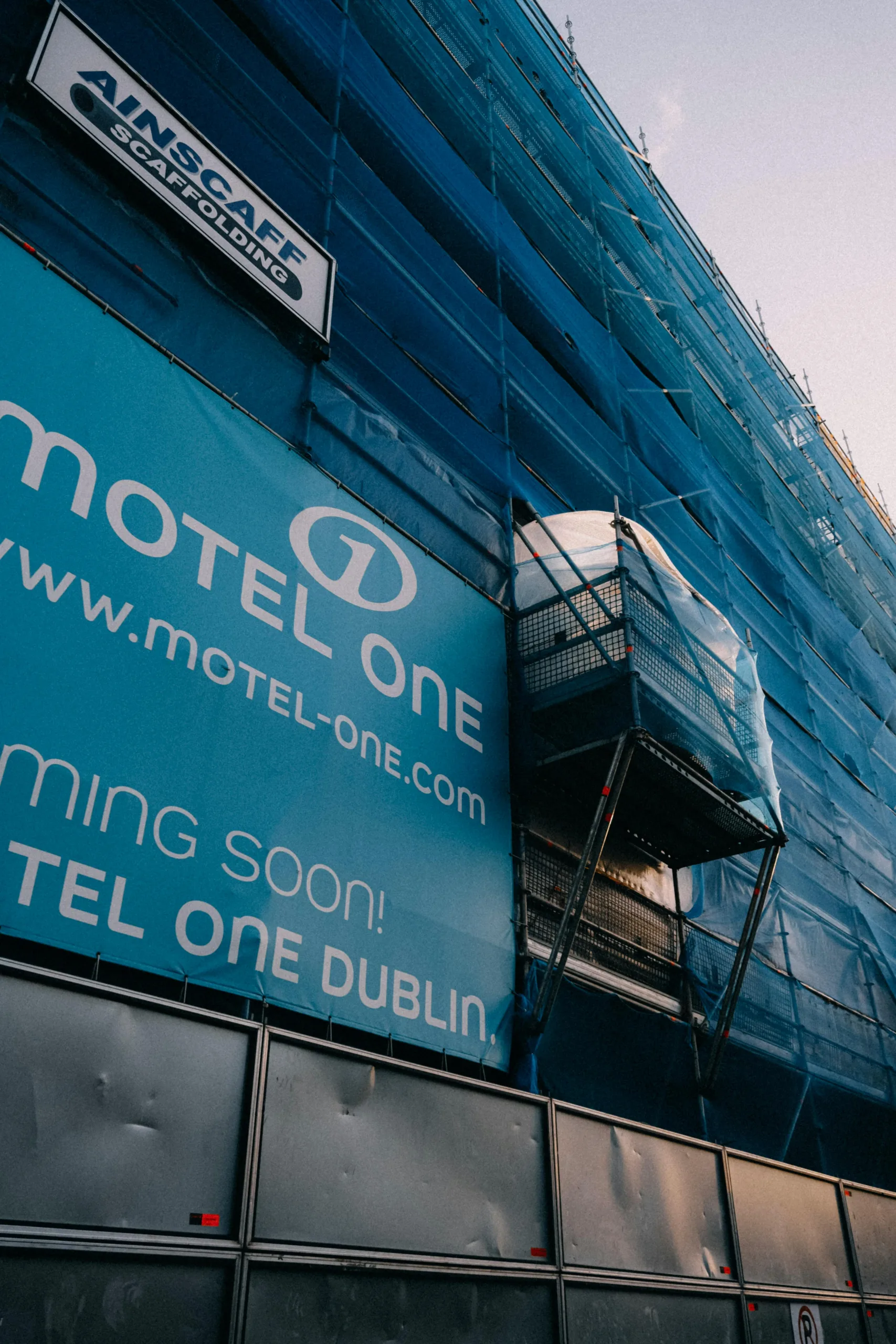 Printed hoarding panels on a construction development site with advertisement graphics
