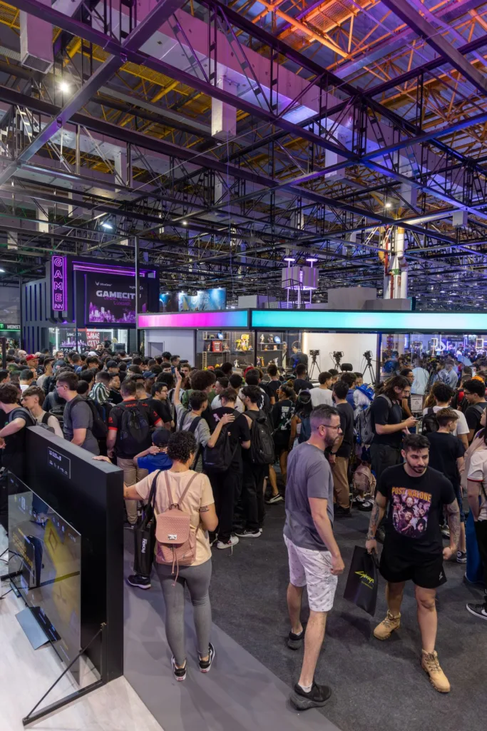 Lively technology convention crowd exploring interactive displays and exhibition booths