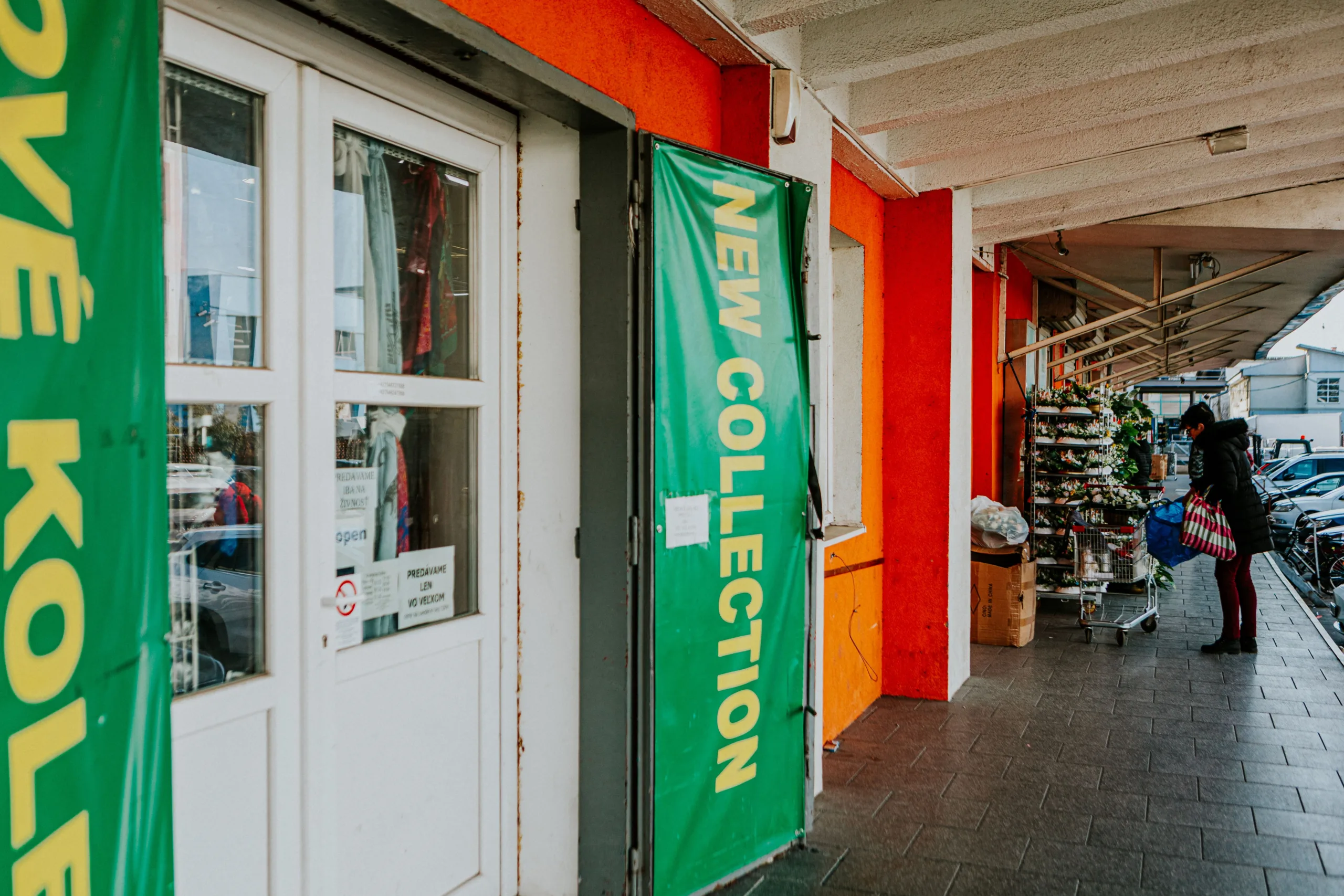 Urban shopping street with retail storefront displaying new collection window signage