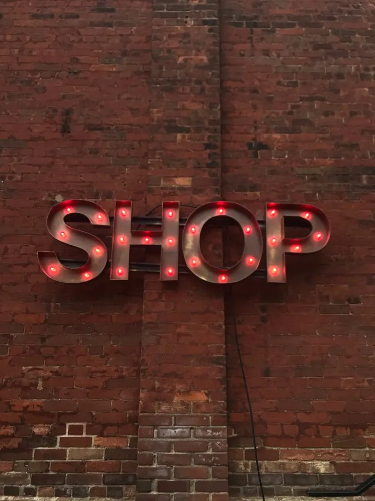 Illuminated SHOP letters mounted on a brick wall