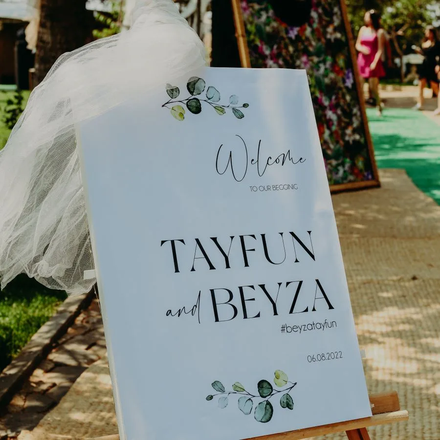 Printed welcome sign display board on a wooden easel at a wedding