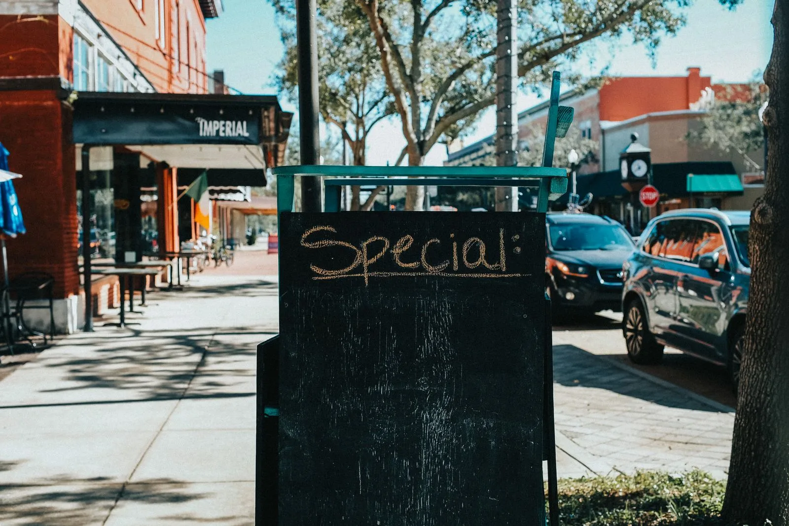 A-board chalkboard sign on a sunny city sidewalk