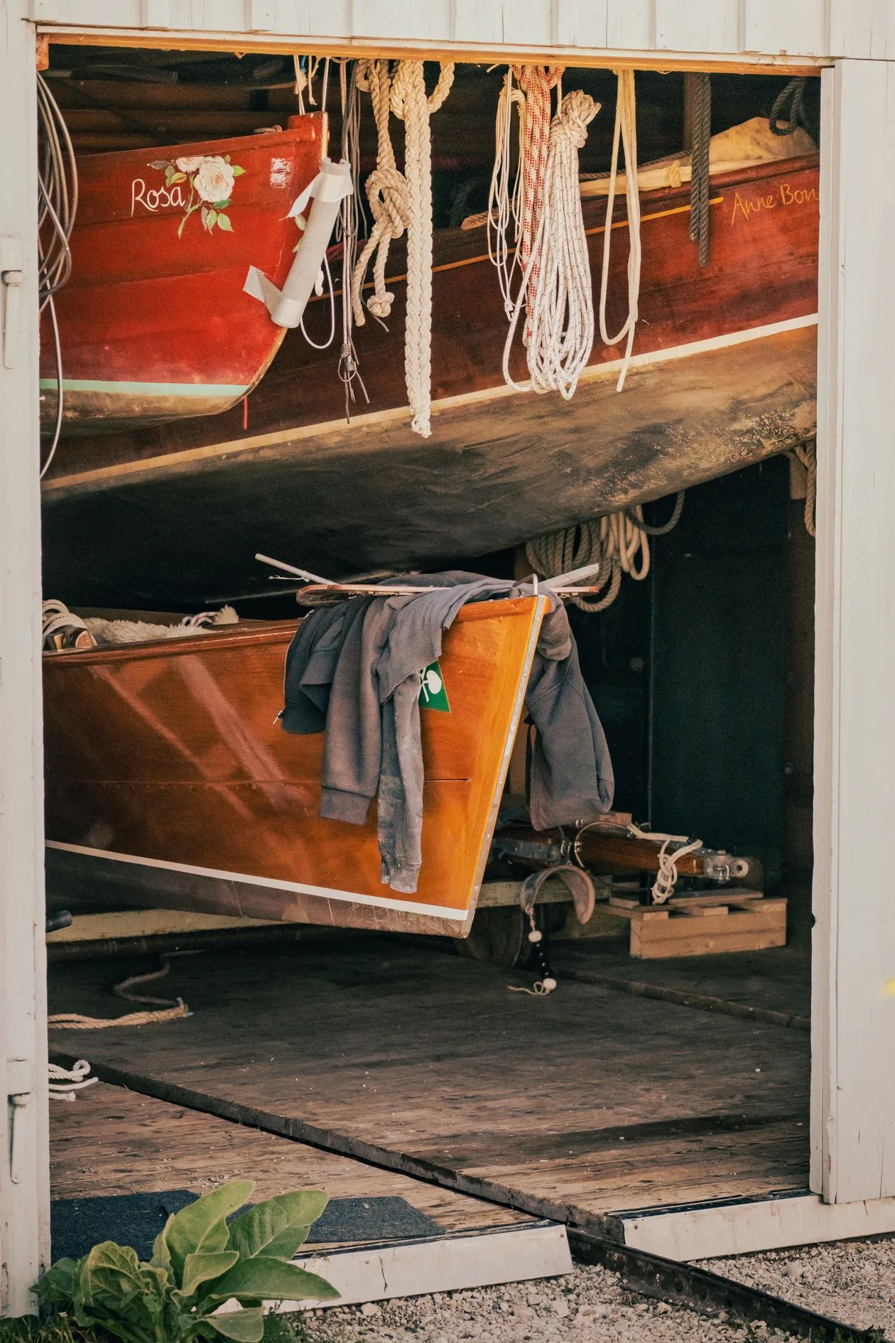 Interior of a boathouse with wooden rowing boats stored on racks