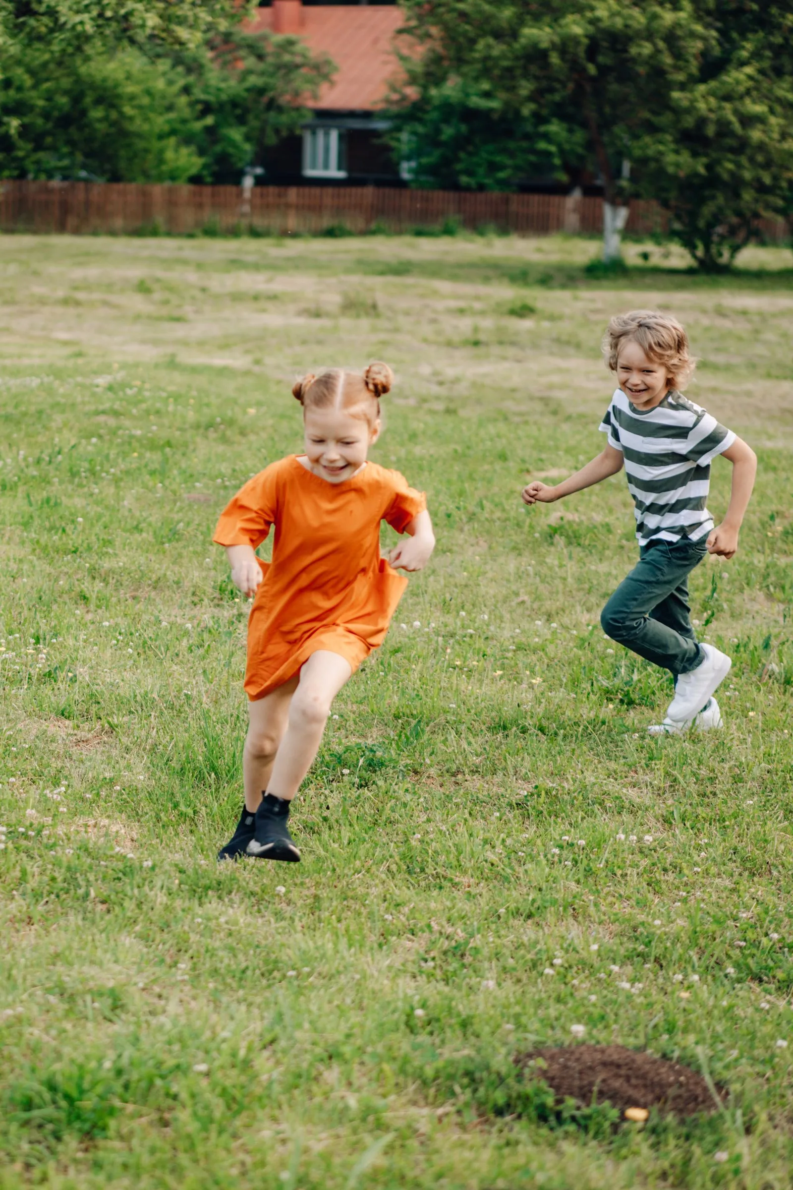 Children running on a grass field during a school sports day