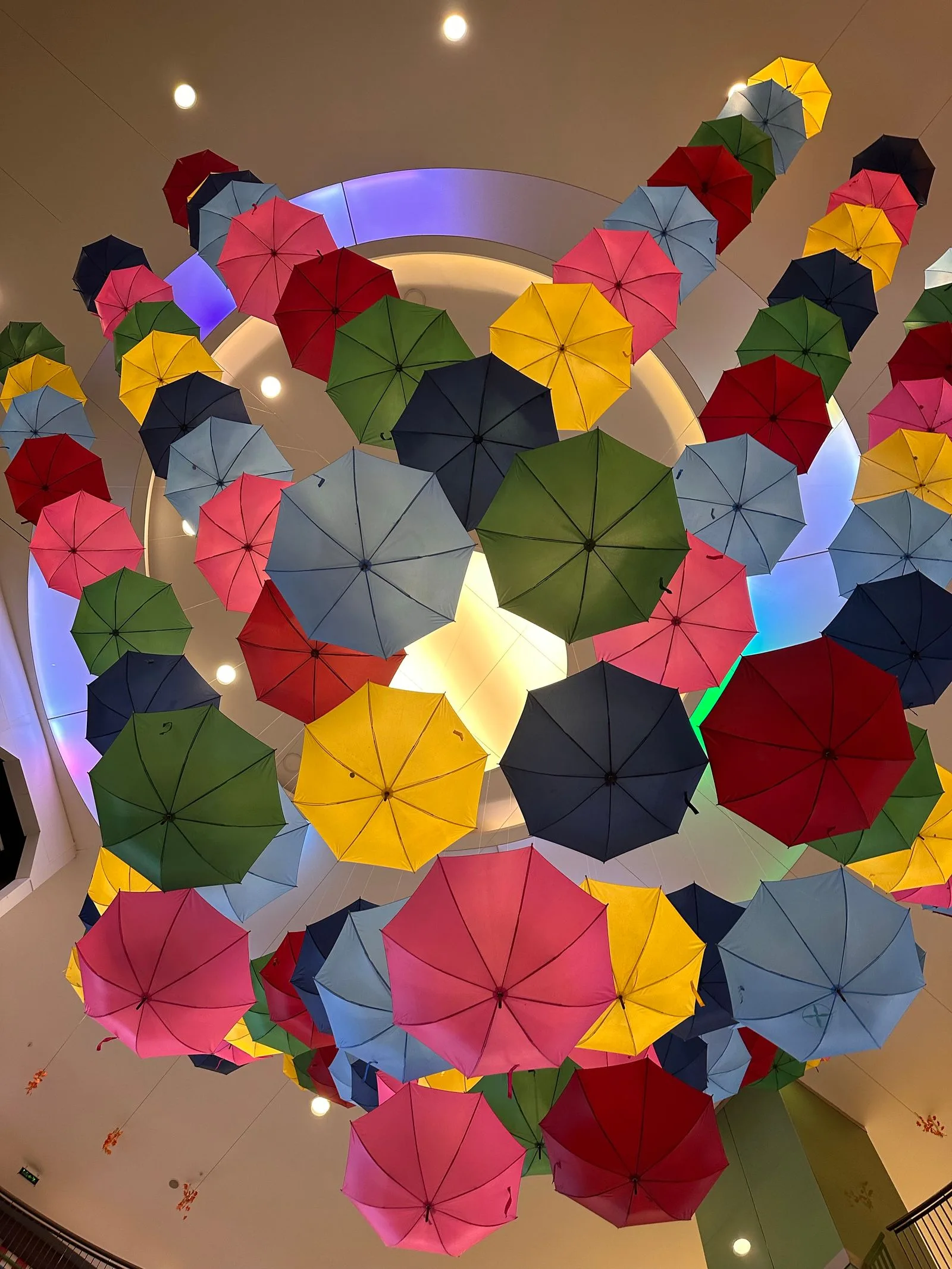Colourful umbrellas hanging as a ceiling display indoors