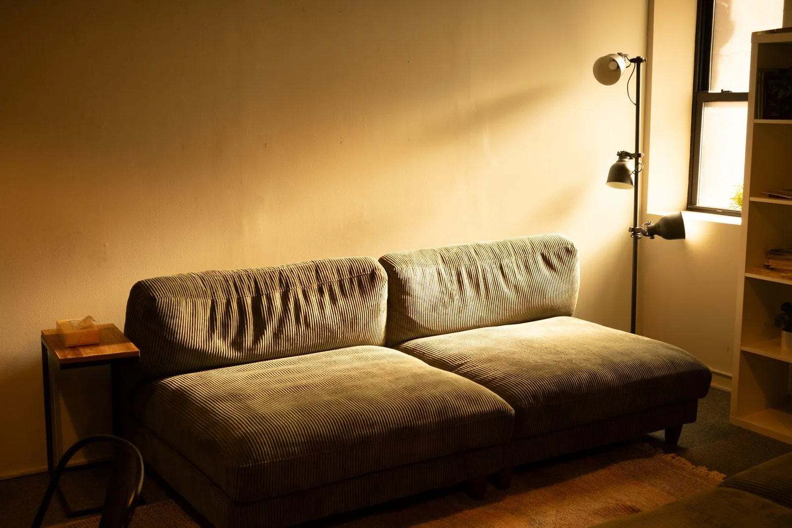 Warm sunlit lounge sofa in a calm, empty communal room