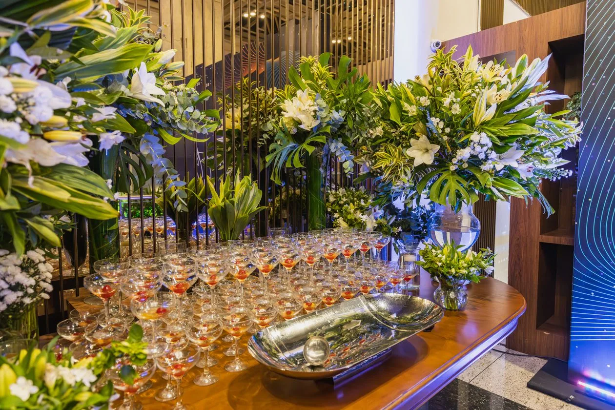 Elegant event reception table with floral arrangements and champagne glasses