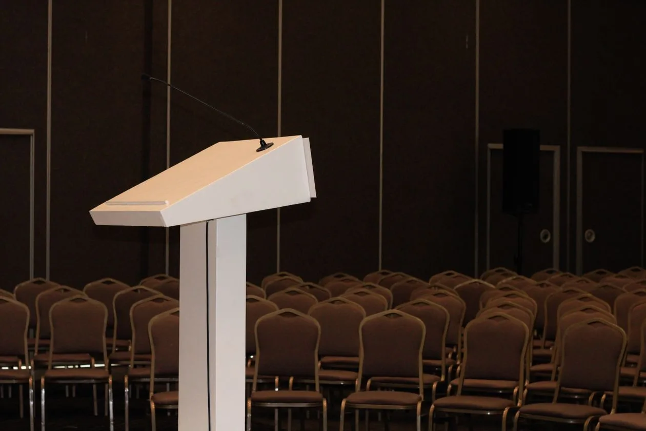 Empty conference room with podium and rows of chairs