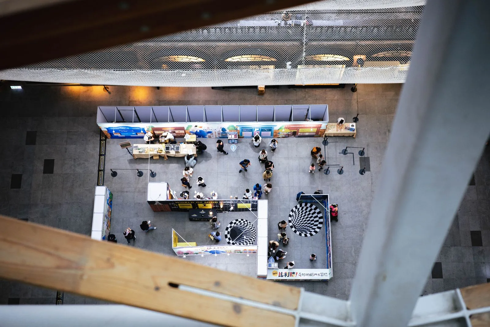 Aerial view of an exhibition hall floor featuring large circular floor graphics