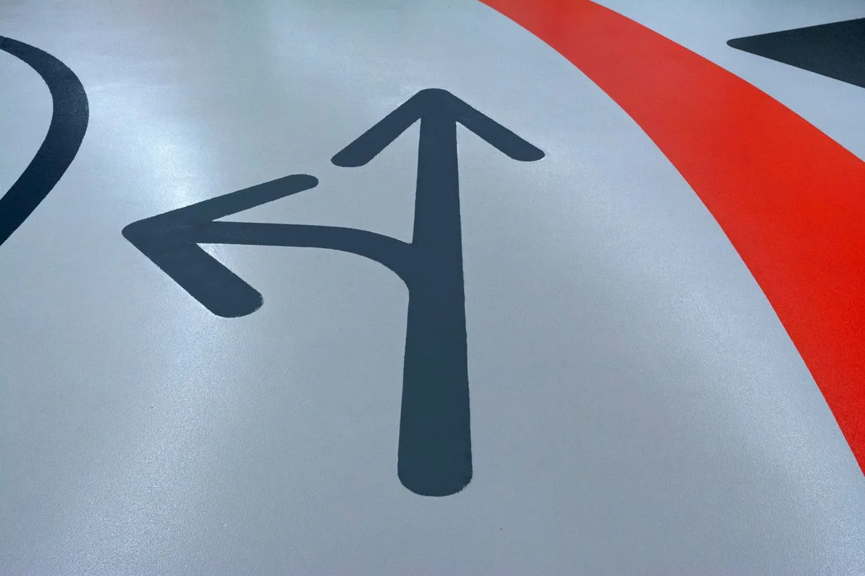 Printed directional arrow floor graphic on a car park surface