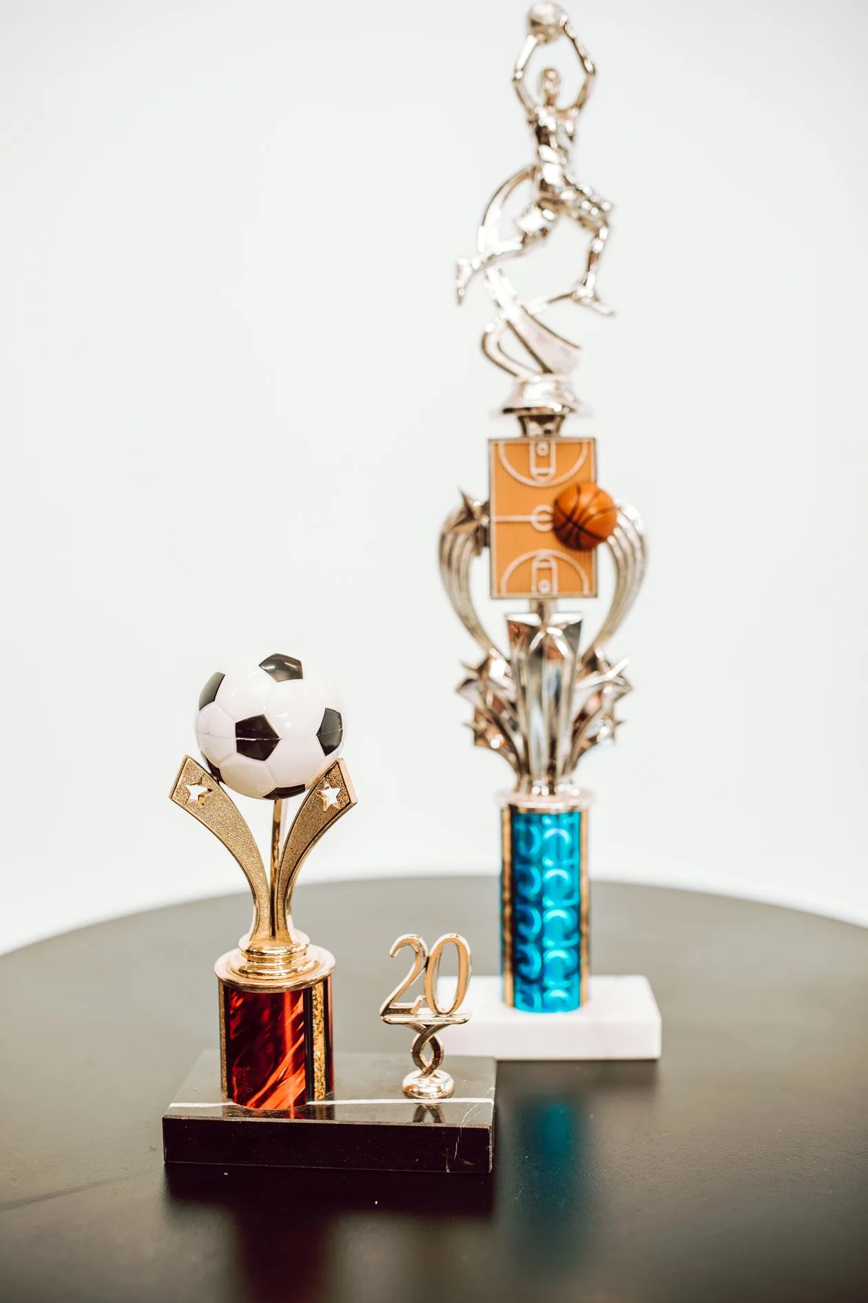 Small sports trophies with football and basketball figures on a table