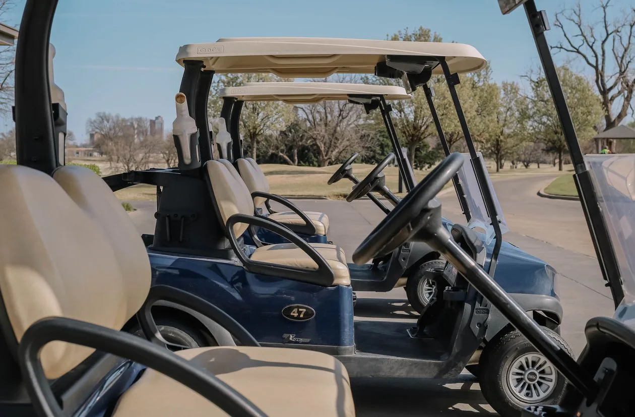 Golf carts parked beside the course near the clubhouse