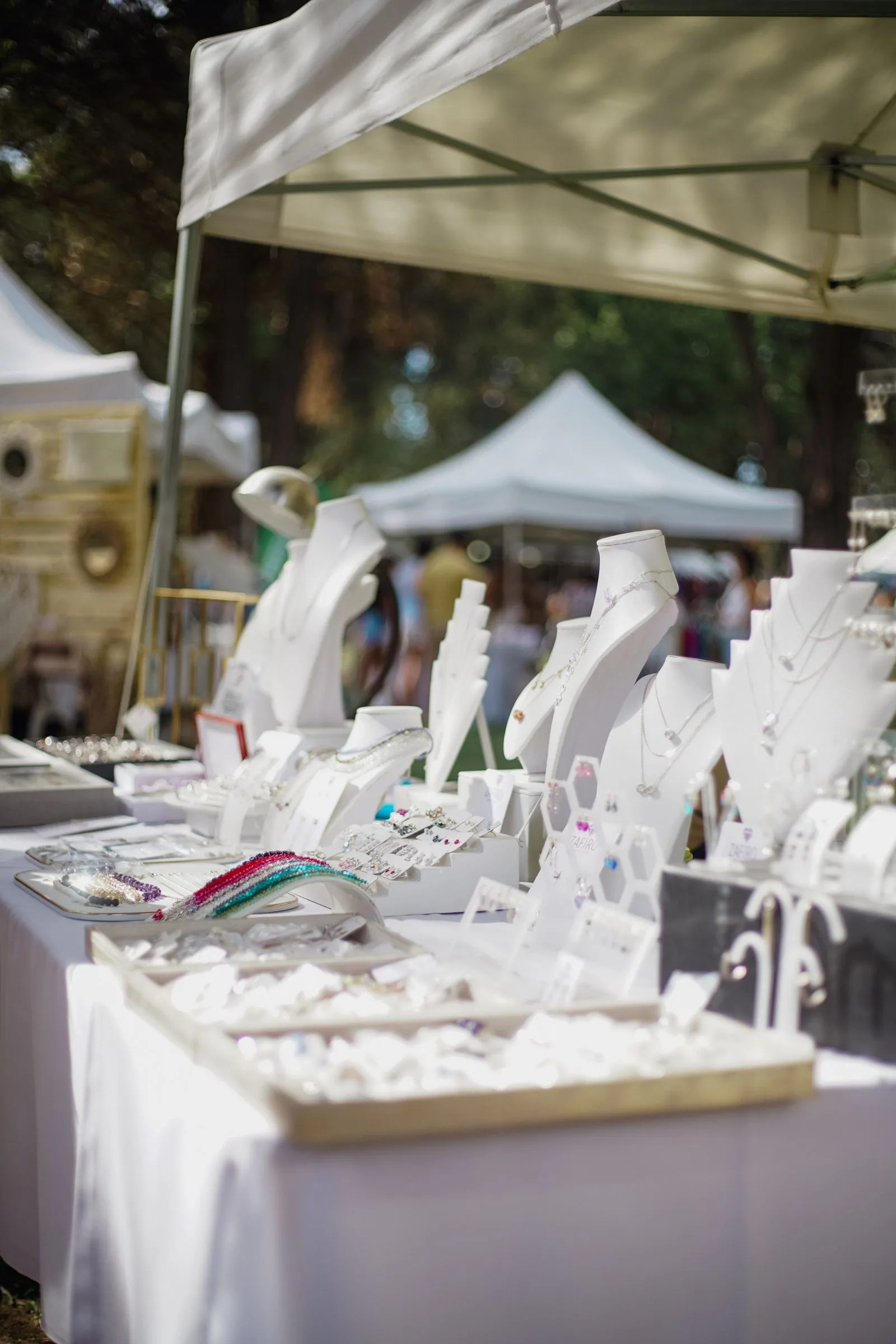 Colourful market stall selling jewellery under white tents