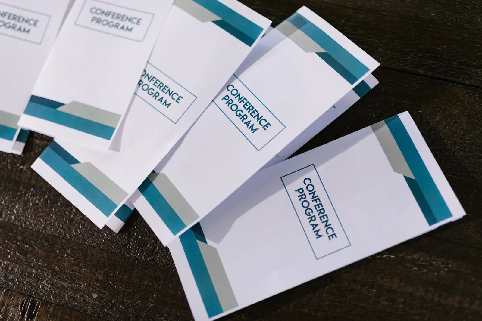 Close-up of printed programme pamphlets on a wooden surface