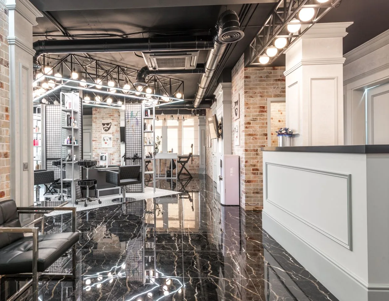 Salon reception counter against a decorated brick wall