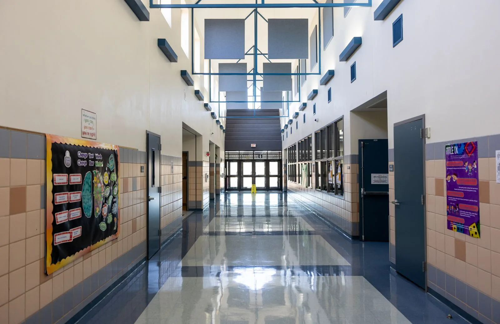 Bright empty school hallway with bulletin boards on the wall