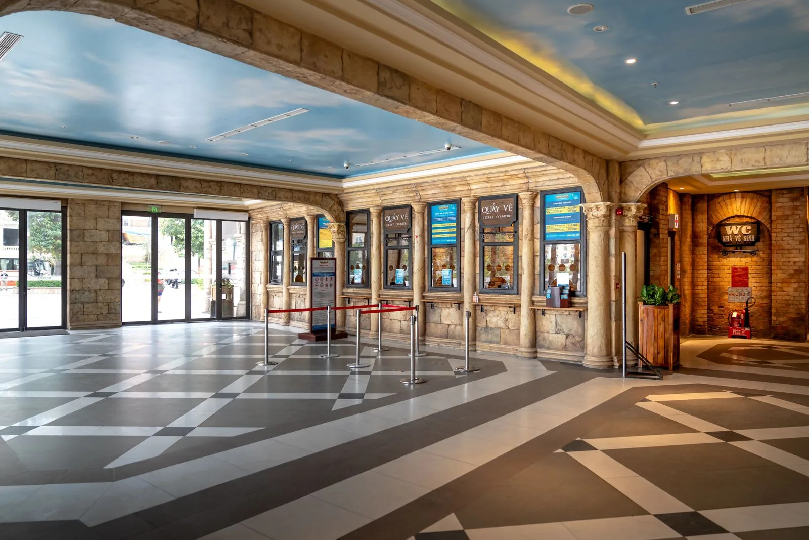 Elegant empty theatre foyer with ticket booth and ornate ceiling