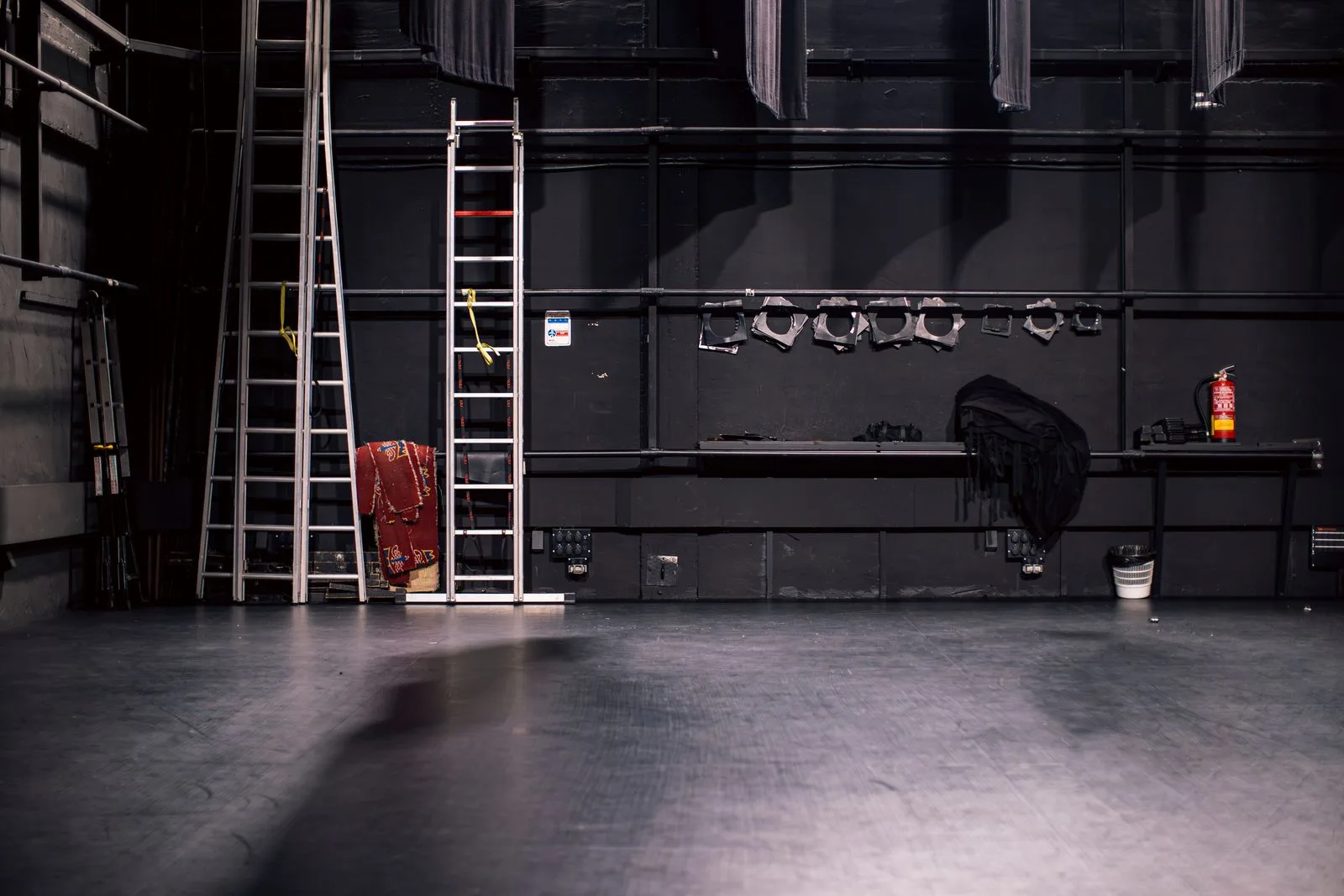 Quiet theatre stage set up with ladders and production equipment